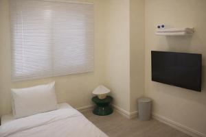 a bedroom with a bed and a flat screen tv at The loft 6 in Busan