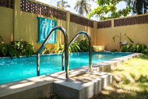 a swimming pool with metal railings next to a building at KAHA by TONIK, Talpe - Pool & Garden in Talpe