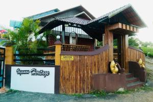 a small house with a wooden fence in front of it at Heritage Vagamon Cottages in Idukki