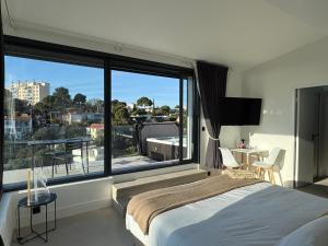 a bedroom with a bed and a large window at La LUNA - VILLA D'ARCHITECTE B&B VUE MER ET JACUZZI in Marseille +47 photos