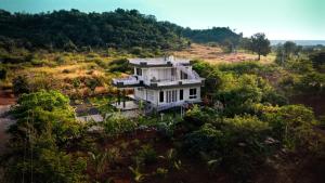 an aerial view of a house on a hill at 'Tatvamasi' Farmstay, Hillock The Nature Retreat, Vikarabad in Morangpalli