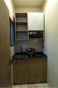a small kitchen with a stove and a microwave at Sanctum Suites in Abuja