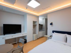a bedroom with a bed and a flat screen tv at 블루앤호텔 in Songjŏng