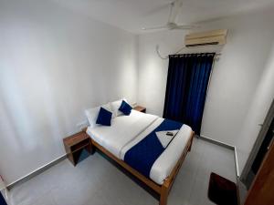 a bedroom with a bed and a blue curtain at Havana Beach Villa in Alleppey +11 photos