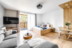a living room with a couch and a bed at Jen tak Lipno in Lipno nad Vltavou