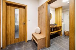 a bathroom with a wooden door and a sink at Jen tak Lipno in Lipno nad Vltavou