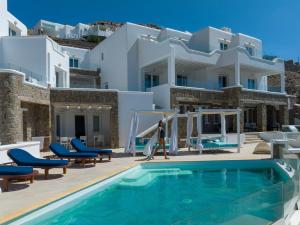 a villa with a swimming pool in front of a house at Arte & Mare Elia Luxury Suites and Villas in Elia Beach
