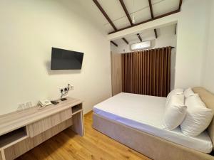 a small room with a bed and a television at The Dimora Residence in Kurunegala
