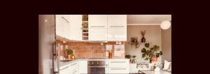 a kitchen with white cabinets and a brick wall at Apartment Aker brygge- Oslo sentrum in Oslo