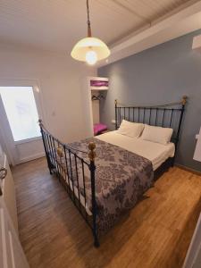 a bedroom with a bed with a black frame at Traditional mama house in Skala Sotiros