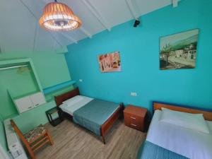 a bedroom with two beds and a blue wall at Traditional mama house in Skala Sotiros