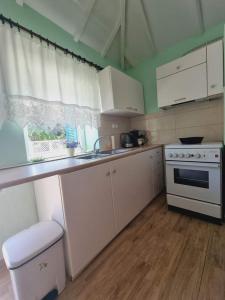 a kitchen with white cabinets and a sink and a stove at Traditional mama house in Skala Sotiros