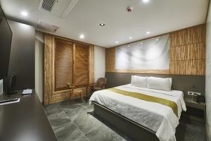 ein Schlafzimmer mit Bett, Schreibtisch und Fernseher in der Unterkunft Aura Tourist Hotel in Ansan + 21 Fotos