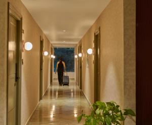 a woman walking down a hallway with a suitcase at Minimalist - The Varanasi Edit in Varanasi