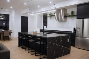 a kitchen with black cabinets and a black counter top at Downtown Luxe Stay - High River in High River