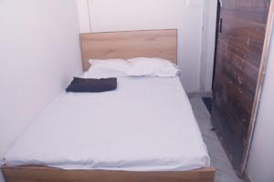 a bed with white sheets and pillows in a room at Privyrooms Taramandal in Gorakhpur +9 photos