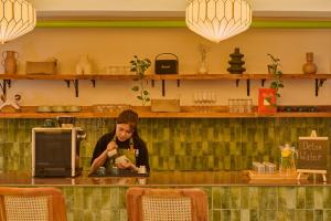 a woman sitting at a counter in a restaurant at Minimalist - The Varanasi Edit in Varanasi