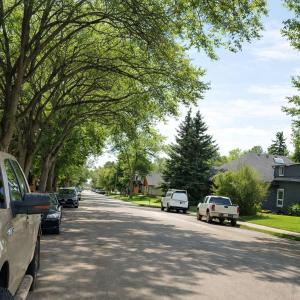 a street with cars parked on the side of the road at Downtown Luxe Stay - High River in High River