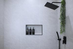 a bathroom with three bottles of wine in a shower at Downtown Luxe Stay - High River in High River +24 photos