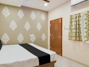 a bedroom with a bed and a door at Hotel O BSS INNS in Warangal