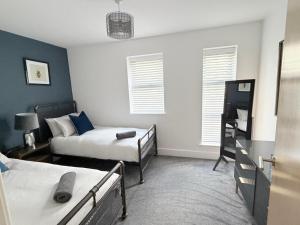a bedroom with two beds and a tv in it at Orchard Point in Southampton +9 photos
