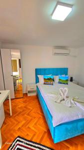 a bedroom with a blue bed with a bow on it at Casa cu Trandafiri Murighiol in Murighiol +53 photos