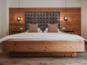 a bedroom with a large bed with a wooden headboard at Hotel Schönberg in Rio Bianco