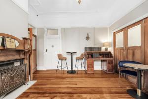a living room with a desk and stools at Hotel Avonleigh in Katoomba