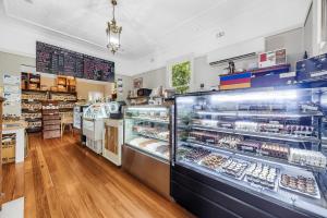 a bakery with a display case filled with pastries at Hotel Avonleigh in Katoomba