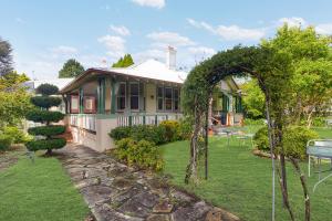 a house with an arch in front of a yard at Hotel Avonleigh in Katoomba