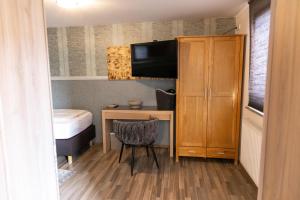 a room with a desk and a bed and a television at Chaplin in Kempten