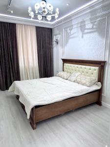 a bedroom with a large bed with a chandelier at Boulevard in Samarkand