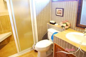 a bathroom with a shower and a toilet and a sink at บ้านไร่คุณนาย in Ban Sap Bon +34 photos