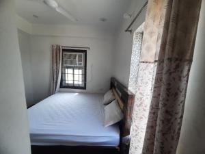 a small bedroom with a bed and a window at Hotel Aditya Bikaner in Deshnoke