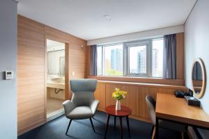 a room with a chair and a desk and a window at Hotel PJ Myeongdong in Seoul +104 photos