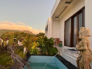 a house with a statue next to a swimming pool at Kayana Lake View in Kubupenlokan