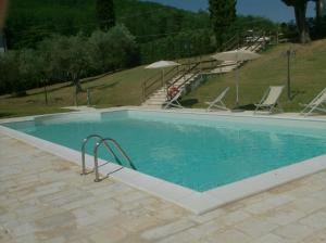 a large swimming pool with chairs and umbrellas at Poggio Desto Bed & Breakfast in Quarrata +21 photos