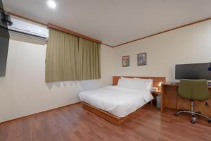 a bedroom with a bed and a desk and a television at Anook Hotel Jeonju in Jeonju