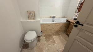 a bathroom with a toilet and a bath tub at Au Soleil Couchant in Wimille +7 photos