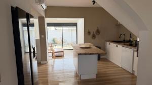 a kitchen with a island in the middle of a room at Au Soleil Couchant in Wimille