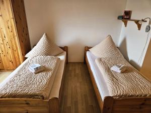 a room with two beds with towels on them at Pension Haus Donaublick in Deggendorf