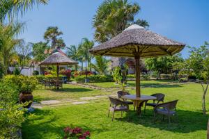 a table and chairs under an umbrella in a garden at Sea Eagle Oceanfront in Buyuni
