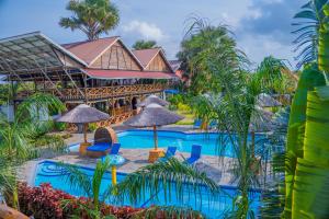 a resort with a swimming pool with palm trees and umbrellas at Sea Eagle Oceanfront in Buyuni