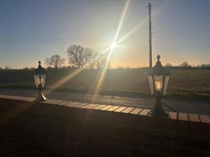Zwei Lichter auf einem Bürgersteig bei Sonnenuntergang in der Unterkunft Penberthy Cabin in Offord Cluny