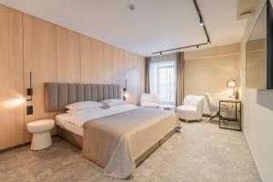 a bedroom with a bed and a desk and chairs at Amberton Cathedral Square Hotel Vilnius in Vilnius