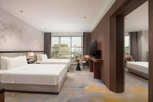 a hotel room with two beds and a television at Liuhua Hotel in Guangzhou