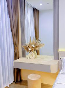 a room with a table with a vase of flowers on it at Homestay Ocean Park Building P3 in Gia Lâm Pho