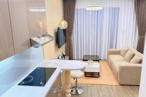 a kitchen and living room with a couch and a table at Homestay Ocean Park Building P3 in Gia Lâm Pho +2 photos