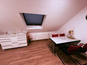 a kitchen with a table and a sink and red chairs at BM Wohnung in Dillingen an der Saar