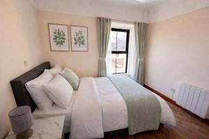 a bedroom with a large bed and a window at The Malting House in Skerries